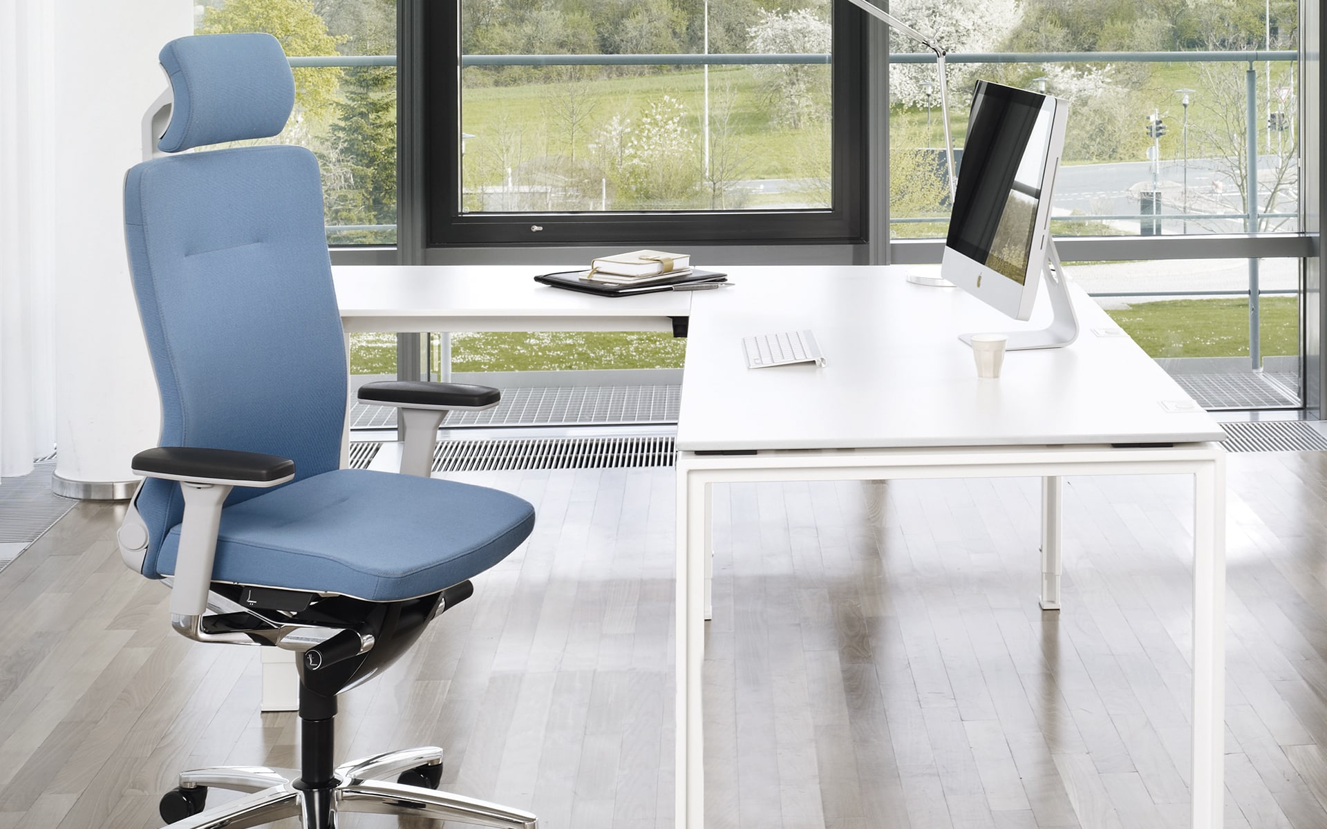 König + Neurath Lamiga office chair by ITO Design with blue upholstery at bright workplace