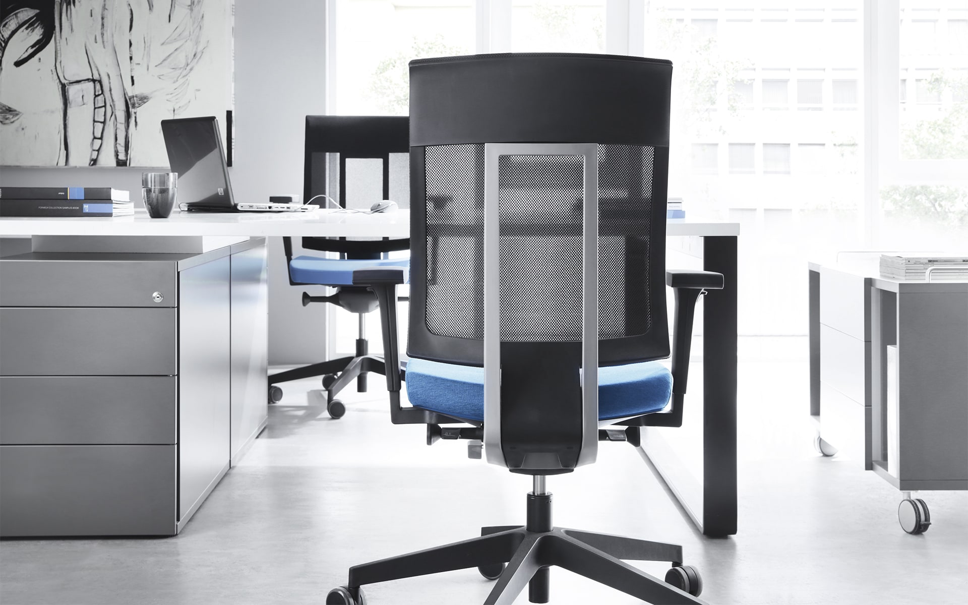 Profim Xenon office chairs by ITO Design with mesh backrests and blue upholstery at modern desk