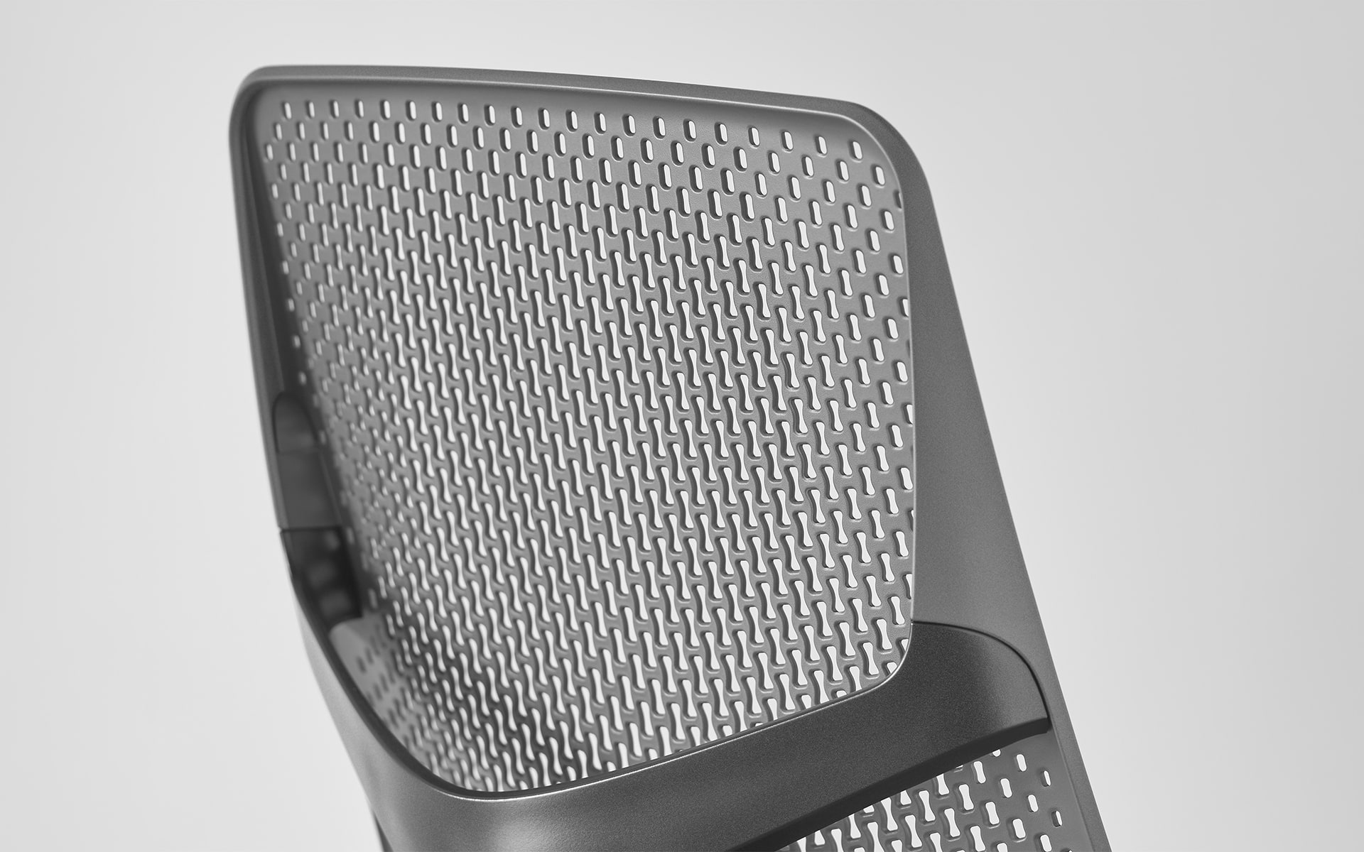 Close-up of the ergonomic perforated plastic backrest of a Hermann Miller Verus office chair by ITO Design