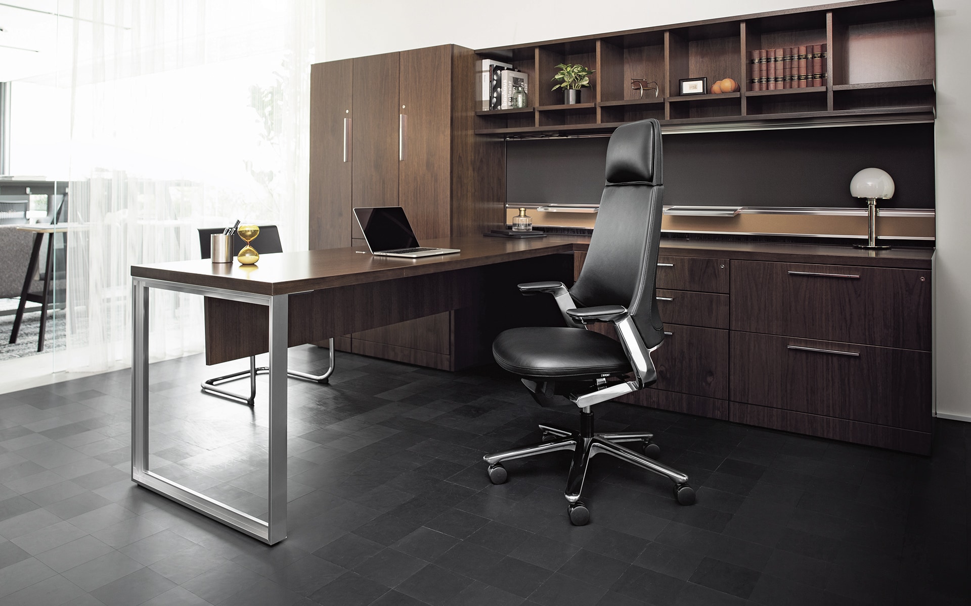 Der ITOKI Leonis Chefsessel von ITO Design in schwarz in elegantem Büro mit Möbeln aus dunklem Holz