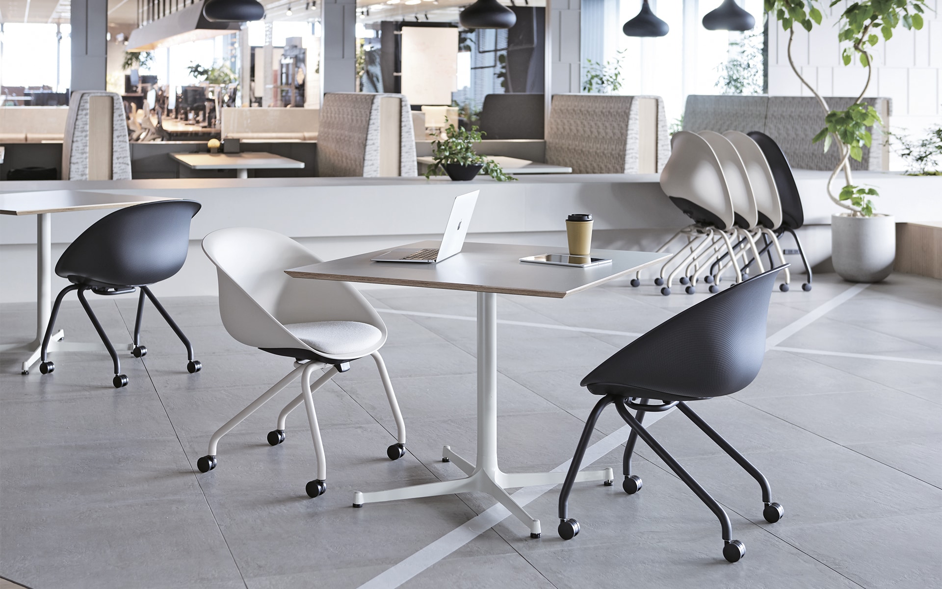 Several ITOKI Wan shell chairs by ITO Design in black and white in modern co-working space