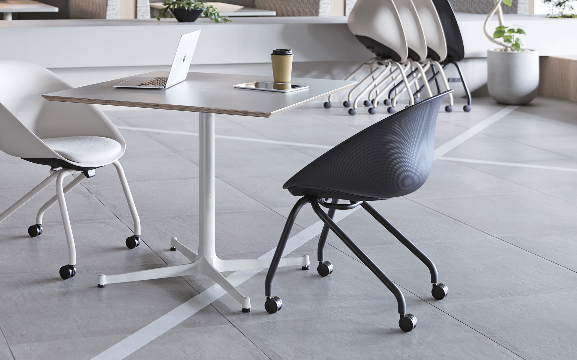 Several ITOKI Wan shell chairs by ITO Design in black and white in modern co-working space