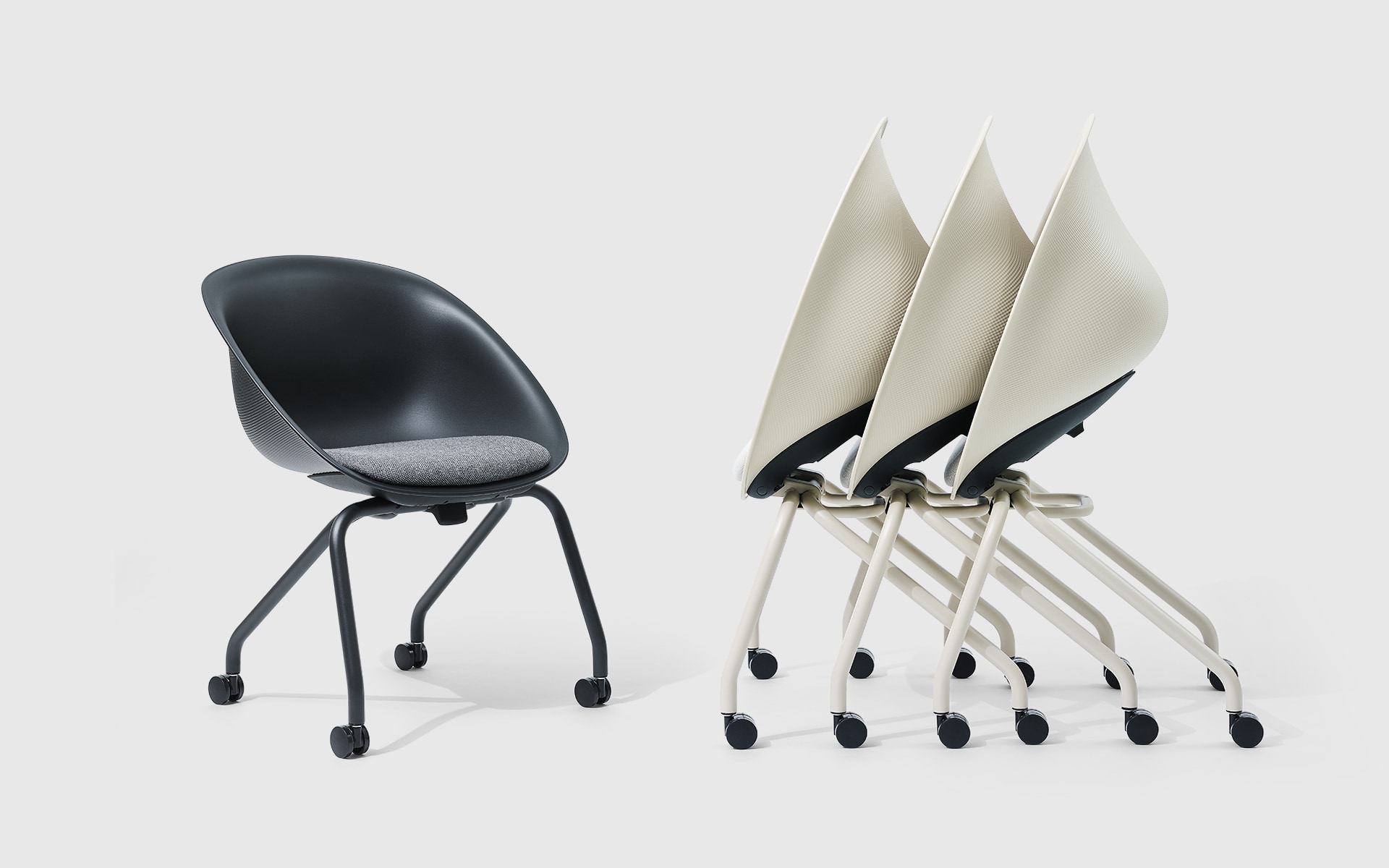 One black and three white, nested ITOKI Wan shell chairs by ITO Design