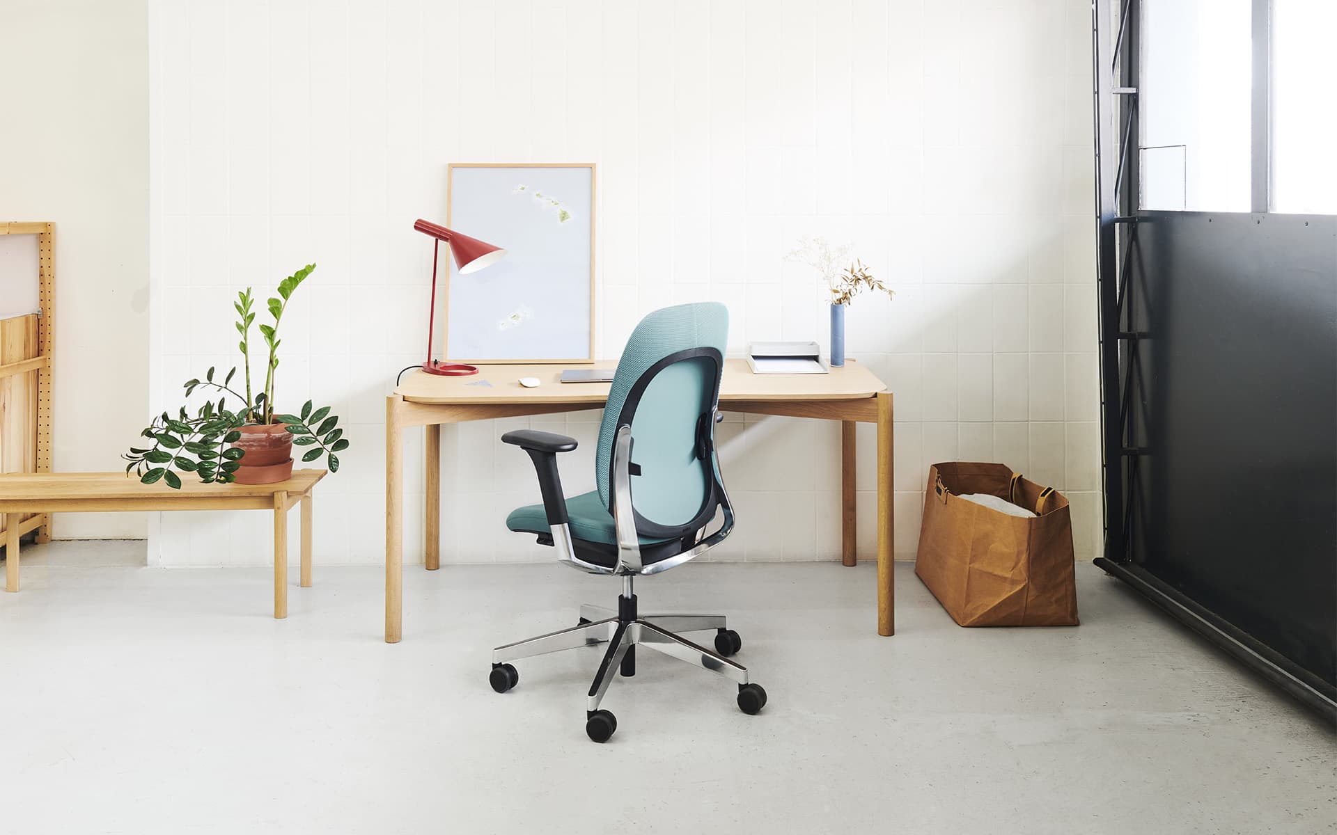 Ein Flokk Giroflex 40 Bürostuhl von ITO Design mit türkisem Bezug an einem gemütlichen Arbeitsplatz – Rückansicht