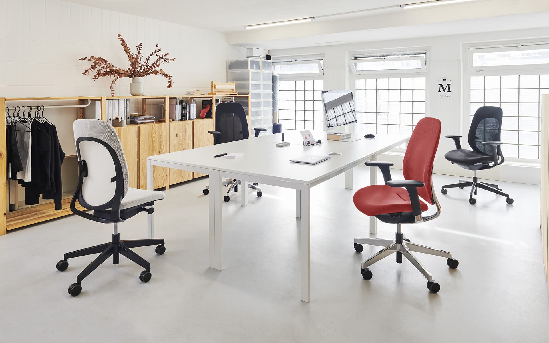 Red, black and white Flokk Giroflex 40 office chairs by ITO Design in a light-filled conference room